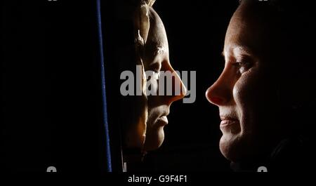 Lyon and Turnbull employee Victoria Crake looks at the Death Mask of Mary Queen of Scots, that is on show at the auctioneers in Edinburgh. Stock Photo