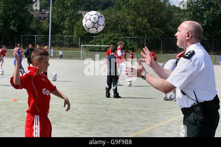 Craig Alexander, 10, from Rathcoole in Belfast, with Superintendent John McCaughan, a police officer with the PSNI at a cross community soccer initiative at the Valley Leisure centre in Newtownabbey, Co Antrim, supported with the services of coaches from Liverpool Football Club. Stock Photo