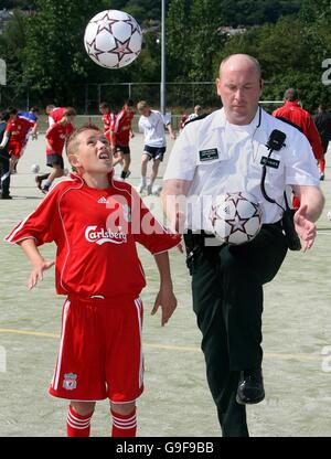 Craig Alexander, 10, from Rathcoole in Belfast, with Superintendent John McCaughan, a police officer with the PSNI at a cross community soccer initiative at the Valley Leisure centre in Newtownabbey, Co Antrim, supported with the services of coaches from Liverpool Football Club. Stock Photo