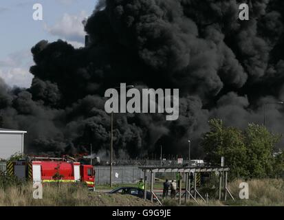 Tyres on fire at a scrapyard dump next to Stanlow Oil Refinery at Ellesmere Port, Cheshire. Stock Photo