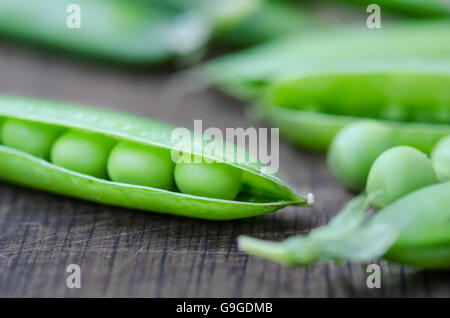 Organic peas pods on wooden table, rustic style Stock Photo