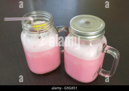 Pink milk in glass mug Stock Photo