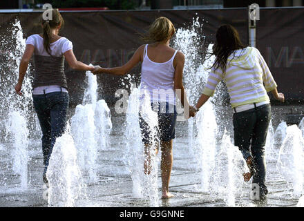 Children play in the water feature in the recently renovated Piccadilly Gardens in Manchester. This year saw the tenth anniversary of the Manchester IRA bombing, since then the city centre has been transformed. Stock Photo