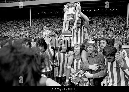Sunderland captain Bobby Kerr (top) holds the FA Cup aloft after his team's 1-0 victory, supported by teammates (l-r) Billy Hughes, Dennis Tueart and goalkeeper Jim Montgomery Stock Photo