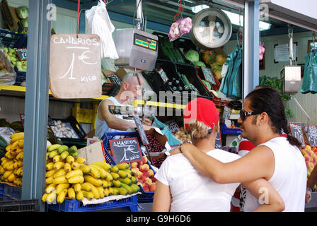 Customer being served at a fruit and veg stall in the indoor market (Mercado de Atarazanas), Malaga, Malaga Province, Spain. Stock Photo