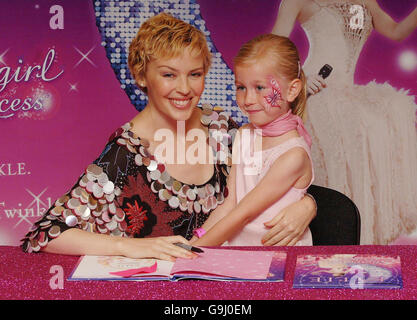 Singer Kylie Minogue with six year old Megan Hondius, as she signs copies of her new book, The Showgirl Princess, at Waterstone's in London. Stock Photo