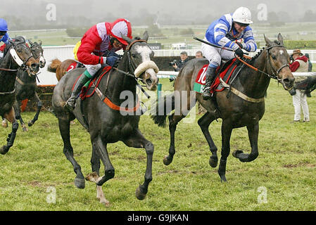 Mith Hill ridden by jockey David Dennis (right) on the way to winning against According To Pete ridden by jockey Fergus King at Cheltenham racecourse. Stock Photo