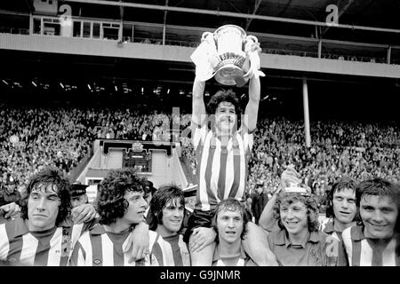Sunderland captain Bobby Kerr (top) lifts the FA Cup as he is supported by teammates (l-r) Vic Halom, Richie Pitt, Billy Hughes, Dennis Tueart, Jim Montgomery, Dave Watson and winning goalscorer Ian Porterfield Stock Photo