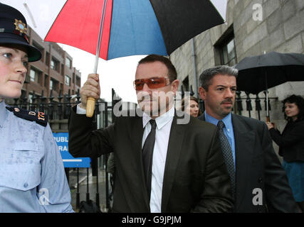 U2 frontman Bono (centre) leaves Dublin High Court after giving evidence in an appeal launched by the band's former stylist. Stock Photo