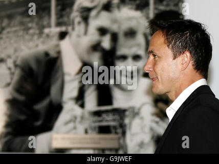 New Leeds United manager Dennis Wise walks past a picture of former Leeds manager Don Revie and captain Billy Bremner as he arrives for a press conference at Elland Road, Leeds. Stock Photo