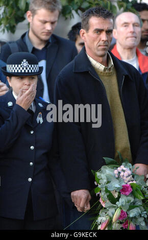 WPC Teresa Milburn and Paul Beshenivsky, husband of the late WPC Sharon Beshenivsky, clutch hands during a memorial service for the officer in Bradford. Stock Photo