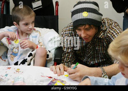 Regan Gibbs, age 5, from Shetland Islands (left), and Danny Jones of pop band McFly design a Christams card at Great Ormond Street Children's Hospital in central London. Stock Photo
