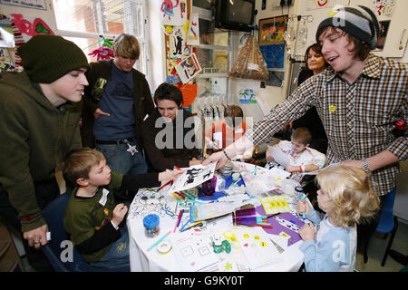 Danny Jones (right), of McFly, hands an autographed band photo to Tom Ursell, age 8 of Epson, as the other members of the band, (left to right) Tom Fletcher, Dougie Poynter and Harry Judd, look on at Great Ormond Street Children's Hospital in central London. Stock Photo