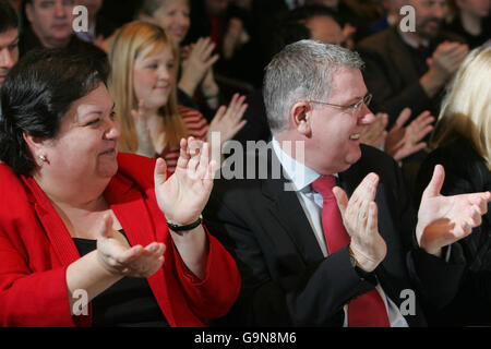 MSP Jackie Bailey (left) and Scottish Health Minister Andy Kerr (right) applaud Scotland's First Minister Jack McConnell (not pictured) after his speech to MSPs and candidates of the Scottish Labour Party at the Corn Exchange in Edinburgh. Stock Photo