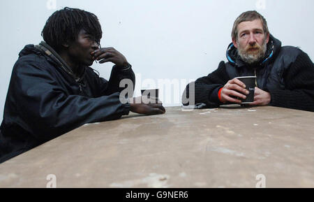 Two homeless people enjoy a cup of coffee at this year's Crisis shelter in east London. Stock Photo