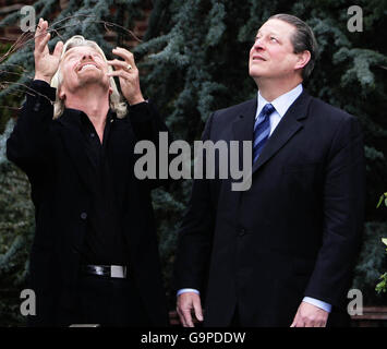 Virgin boss Sir Richard Branson holds a globe as former US vice president Al Gore looks on at the kensington Roof Gardens in London, after he announced a new initiative in the fight against global warming. Stock Photo