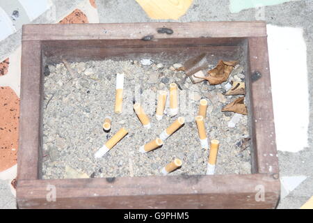 Cigarette butts in a big ashtray full of sand Stock Photo