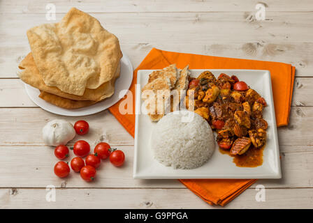 Indian chicken jalfrezi with basmati rice, naan bread and pappadums Stock Photo