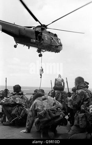 Marines from 40 Commando crouched on the flight deck of HMS Hermes in the South Atlantic, waiting to emplane onto Sea King helicopters. Stock Photo