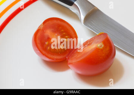 A single red tomato sliced open with a knife Stock Photo