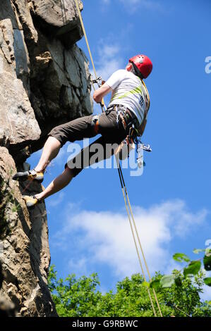 Person Absailing People abseiling in rock climbing lesson Stock Photo - Alamy