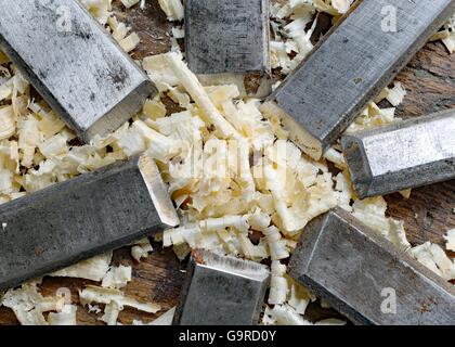 series of many sharp steel blades many chisels and sawdust chippings in Workbench Stock Photo