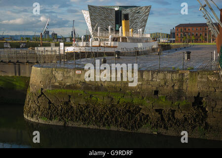 The Titanic Belfast Visitor Experience Centre with SS Nomadic in the foreground Stock Photo