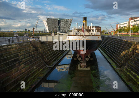 The Titanic Belfast Visitor Experience Centre with SS Nomadic in the foreground Stock Photo