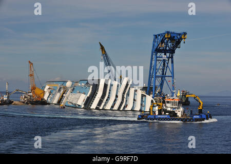 Recovery work at sinking cruise liner, Costa Concordia, at harbour of Island Giglio, Tuscany, Italy / cruise ship, Isola del Giglio Stock Photo