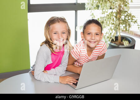Kids using laptop in library Stock Photo