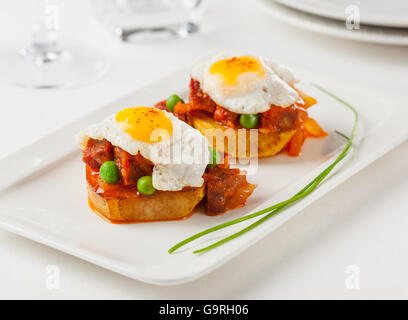 Chorizo and fried egg on a potato slice. Small plate for sharing. Stock Photo