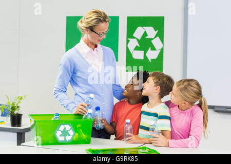 Teacher and kids interacting with each other in classroom Stock Photo