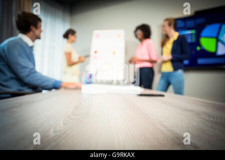 Woman discussing flowchart on white board with coworkers Stock Photo