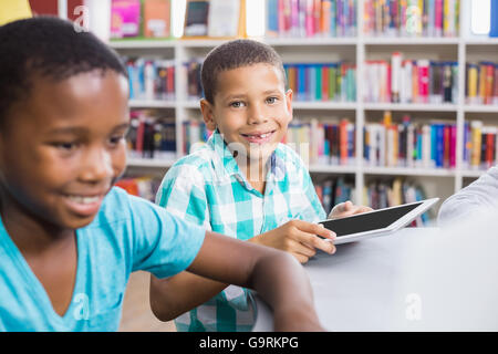 Kids using digital tablet in library Stock Photo