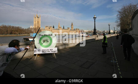 Archer Steve Nicholson fires an arrow at a board with the bullseye representing the need for the climate change law to include targets for cutting the carbon dioxide emissions by an average of at least 3% a year, at a stunt organised by Friends of the Earth in central London. Stock Photo
