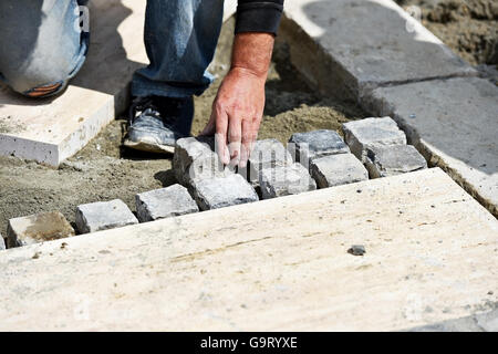 Detail with installation works of cobblestone by a mason Stock Photo