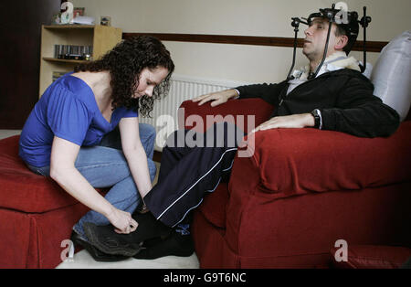 Hero train driver Iain Black has his shoes put on by partner Janice Duff, 29, in Dumbarton, where he spoke about the train crash he was involved in. Stock Photo