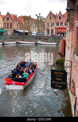 Tourists enjoying a boat trip on the canals of Bruges in Belgium. Stock Photo