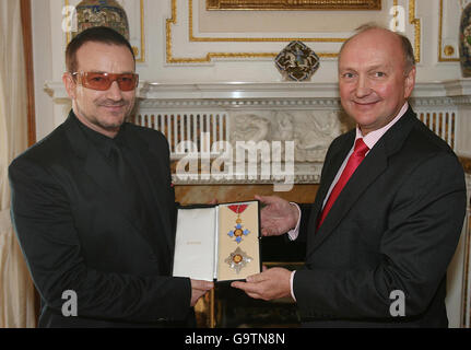 Bono (left) receives his honorary knighthood from British Ambassador David Reddaway at the ambassador's official residence in Sandyford, Dublin. Stock Photo