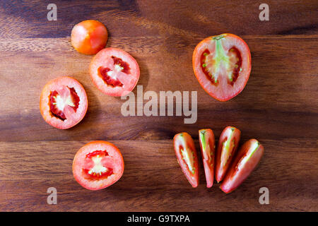 Sliced fresh red tomato on wooden plank Stock Photo