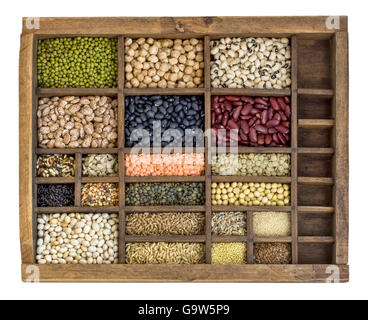 assorted beans, lentils, grains and seeds in an old, wooden typesetter drawer isolated on white Stock Photo