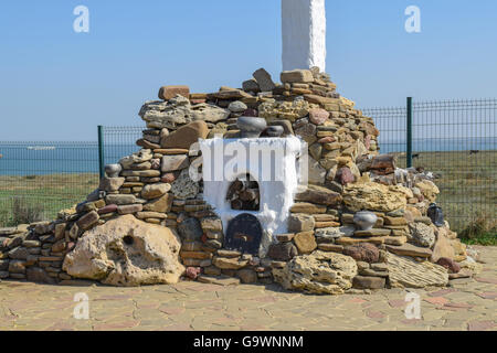 Outdoors whitewashed stove high chimney, lined with pebbles and shell stone. Decorated stone Russian stove for cooking food on t Stock Photo