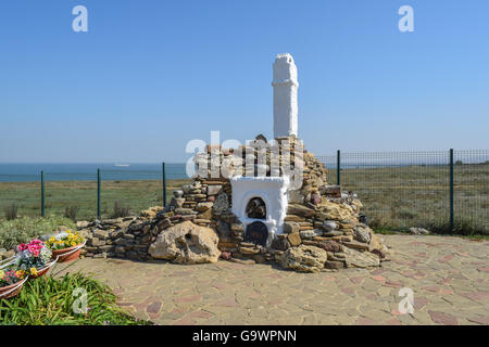Outdoors whitewashed stove high chimney, lined with pebbles and shell stone. Decorated stone Russian stove for cooking food on t Stock Photo