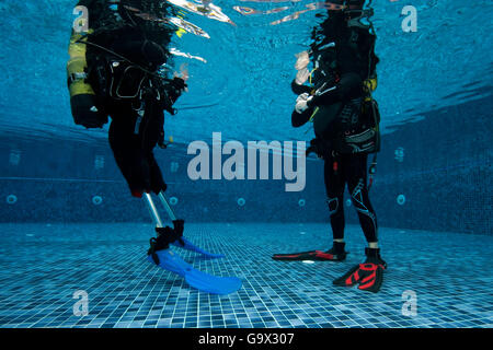 Handicapped diver with leg prothesis and dive instructor Stock Photo