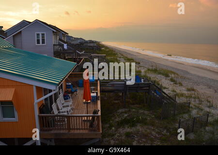 Storm clouds at sunrise over the beach cottages on the Atlantic on Long Beach at Oak Island North Carolina. Stock Photo