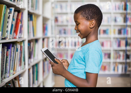 Schoolboy using digital tablet in library Stock Photo