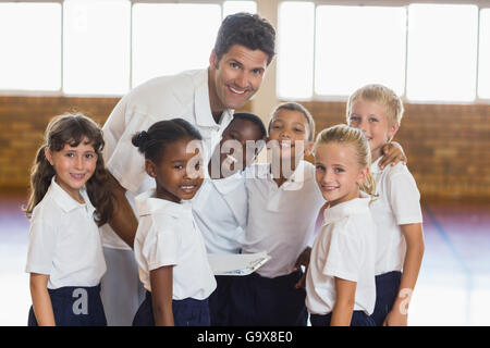 Portrait of sport teacher and students in school gym Stock Photo