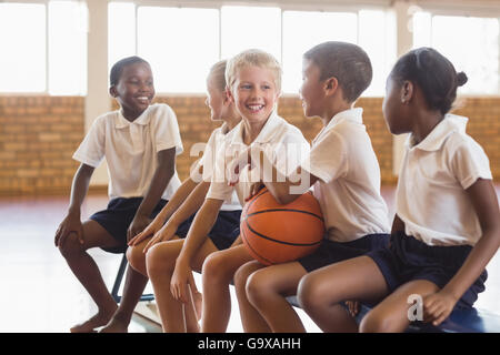 Students sitting on bench talking with each other Stock Photo