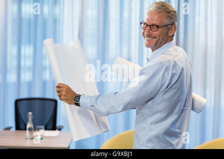 Portrait of man holding blueprint Stock Photo