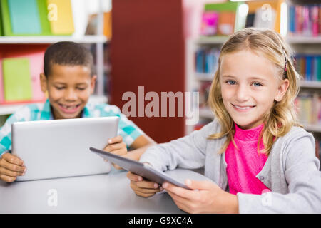 Kids using digital tablet in library Stock Photo